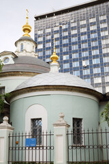 Obraz premium Old church Cosmas and Damian and tall building in Moscow, Russia at summer