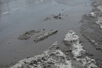Melted snow on road. Large puddle in spring. Lots of water on asphalt.
