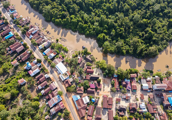 Residential center on the edge of a river and forest in a rural area, on the edge of a cross-regional road, in East Kotawaringin Regency, Central Kalimantan, Indonesia, seen from an aerial view. - obrazy, fototapety, plakaty