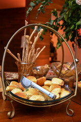 baker's day, mini loaves of bread in a basket, basket of bread on a wooden table, buffet, bakery display, various breads
