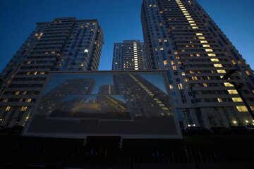 Translaion picture onto the big screen from notebook in the yard of a residential complex