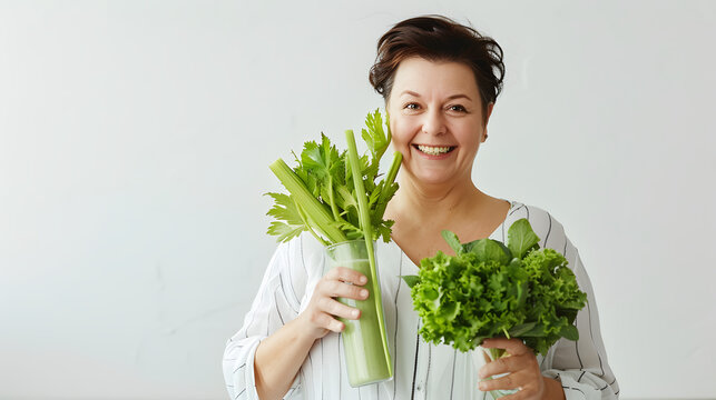 Cheerful overweight woman holding a bunch of green celery in a modern kitchen. Healthy eating and diet concept. Design for nutrition blog, cooking class poster, and healthy lifestyle banner