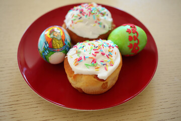  Colorful Easter egg with the inscription Grand Duke John and cakes on a red plate on a wooden table