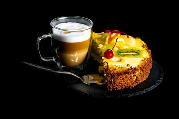 Coffee and cake. Latte or cappuccino in a double glass cup and a fruit cake.