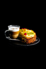 Coffee and cake. Latte or cappuccino in a double glass cup and a fruit cake.