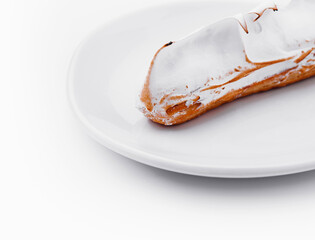 eclair with meringue on white plate