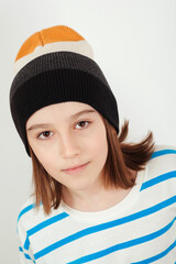 Cute boy wearing stylish woolen hat. Kid posing over white background.
