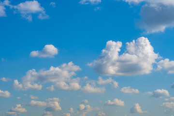 Summer sky with low white clouds. Blue sky with clouds receding into perspective.