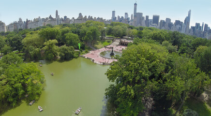 Cityscape and Bethesda Terrace with Angel of the Waters fountain near The Lake in Central Park at summer day. Aerial view. Bethesda Fountain constructed in 1859-64.