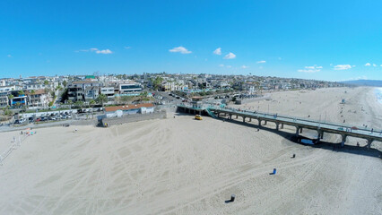  People walk by Manhattan Beach with long pier at autumn sunny day. Aerial view. Pier is 928 feet long.