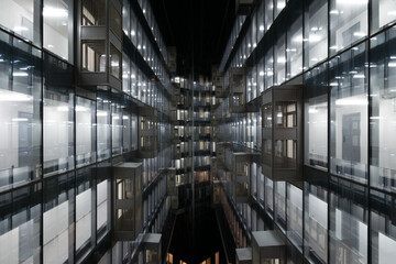 Beautiful illuminated windows of modern building at dark night in city