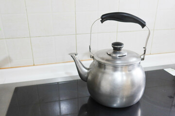 silver stainless steel pot kettle with Whistle function for boil water placing on the stove in...