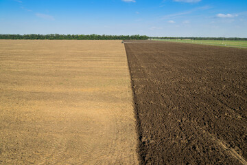  Modern green tractor plows field after harvest, 