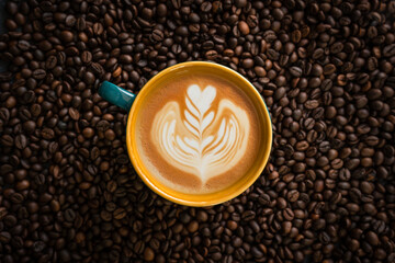 cup of designed Cappuccino isolated on coffee beans background, flatly image of latte art coffee photography
