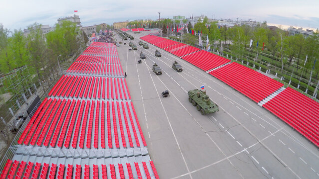  Military motorcade moves along empty tribunes during parade rehearsal at spring evening. Aerial view video frame
