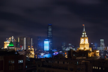 Fototapeta na wymiar Shanghai - river, illuminated skyscrapers at night, Clock of Shanghai Custom
