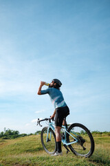 Obraz premium A middle age man drinking water in his gravel bike.