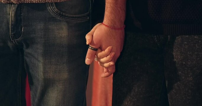 Guy and girl holding hands close up