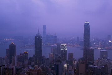 Fototapeta na wymiar Night view of city in fog and Victoria Harbour in Hong Kong, China, view from Queen Garden