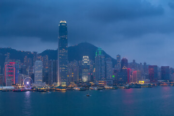 Evening International Commerce Centre with illumination, sea shore, mountains and ships in Hong Kong, China, view from Starhouse