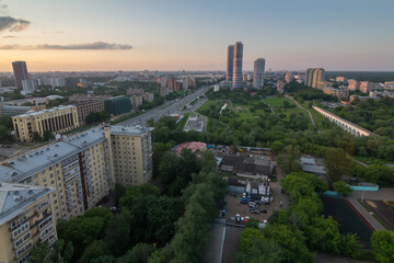 Fototapeta na wymiar Road, green park and skyscrapers in Moscow, Russia at summer evening