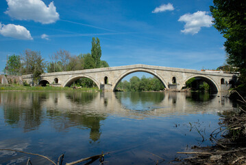 The ancient Roman bridge over a river in Bulgaria, featuring beautiful symmetrical arches reflected...