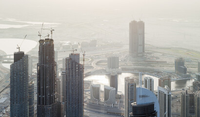 Buildings under construction in Business Bay area, desert far away in Dubai, United Arab Emirates