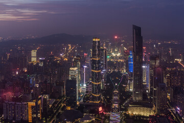 Obraz premium Big modenr Guangzhou city with illumination in fog, China, mountains far away
