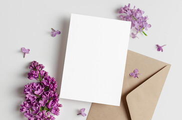 Blank wedding invitation card mockup with spring lilac flowers, top view, copy space