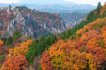 カラフルな紅葉に染まる山と岩が多い山肌