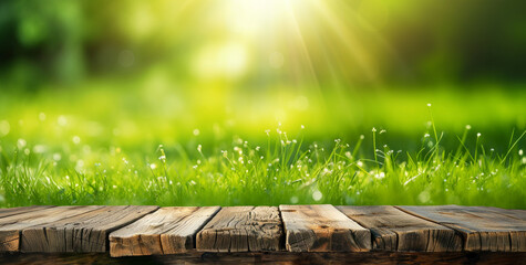 Empty wooden tabletop with sunlit green grass and soft bokeh lights in the background - 755759319