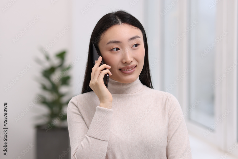 Canvas Prints Portrait of smiling businesswoman talking on smartphone in office