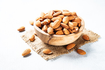 Almond nuts in wooden bowl at white background. Close up.