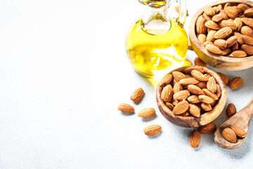 Almond nuts and almond oil at white background. Healthy fat, omega 3 sources.