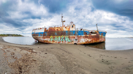 Abandoned Rusty Shipwreck on a Desolate Beach Landscape