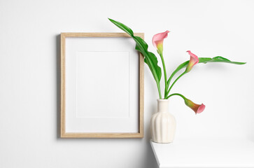 White blank portrait frame mockup with calla flowers