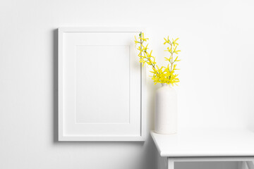 Blank frame mockup in white interior with flowers