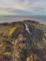 The rocky coast of the Barents Sea. Beautiful view of the rocks and the coast of the Rybachy and Sredny peninsulas, Murmansk region, Russia. The landscape is the harsh beauty of the north.