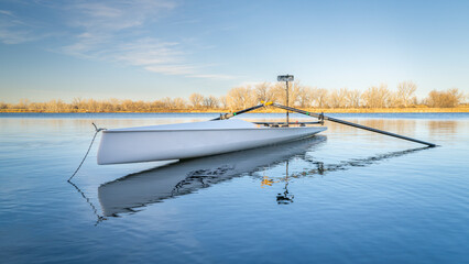 Coastal rowing shell by on a lake in northern Colorado in winter or early spring scenery.