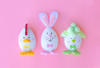 funny decorated easter eggs on a pink background