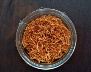 Dried shredded carrots in a glass jar on a dark wooden background