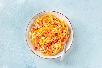 Carbonara pasta dish, traditional Italian spaghetti with pancetta and cheese, overhead flat lay shot with a fork - 755790303