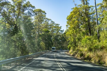 tourist traveling in a caravan exploring nature driving on a raod in the forest Cars Driving on a highway road, in australia