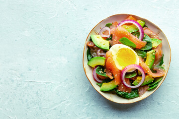 Salmon, avocado and egg salad with fresh leaves and onions, overhead flat lay shot on a slate background. Healthy diet. with copy space - 755791714