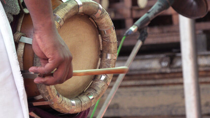 An artist playing Thavil, a South Indian percussion musical instrument