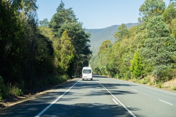 tourist traveling in a caravan exploring nature driving on a raod in the forest Cars Driving on a...