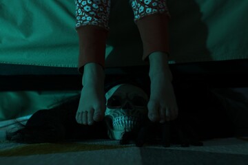 Childhood phobia. Girl and scary monster under bed at home, closeup