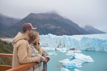 Couple at the background of ice filed in Perito Moreno Glacier National Park