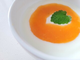 Creamy portion of protein dessert with melissa leaf.