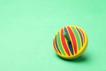 One bright spinning top on aquamarine background, space for text